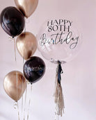  A black and gold birthday balloon with the words "Happy Birthday" printed in elegant lettering