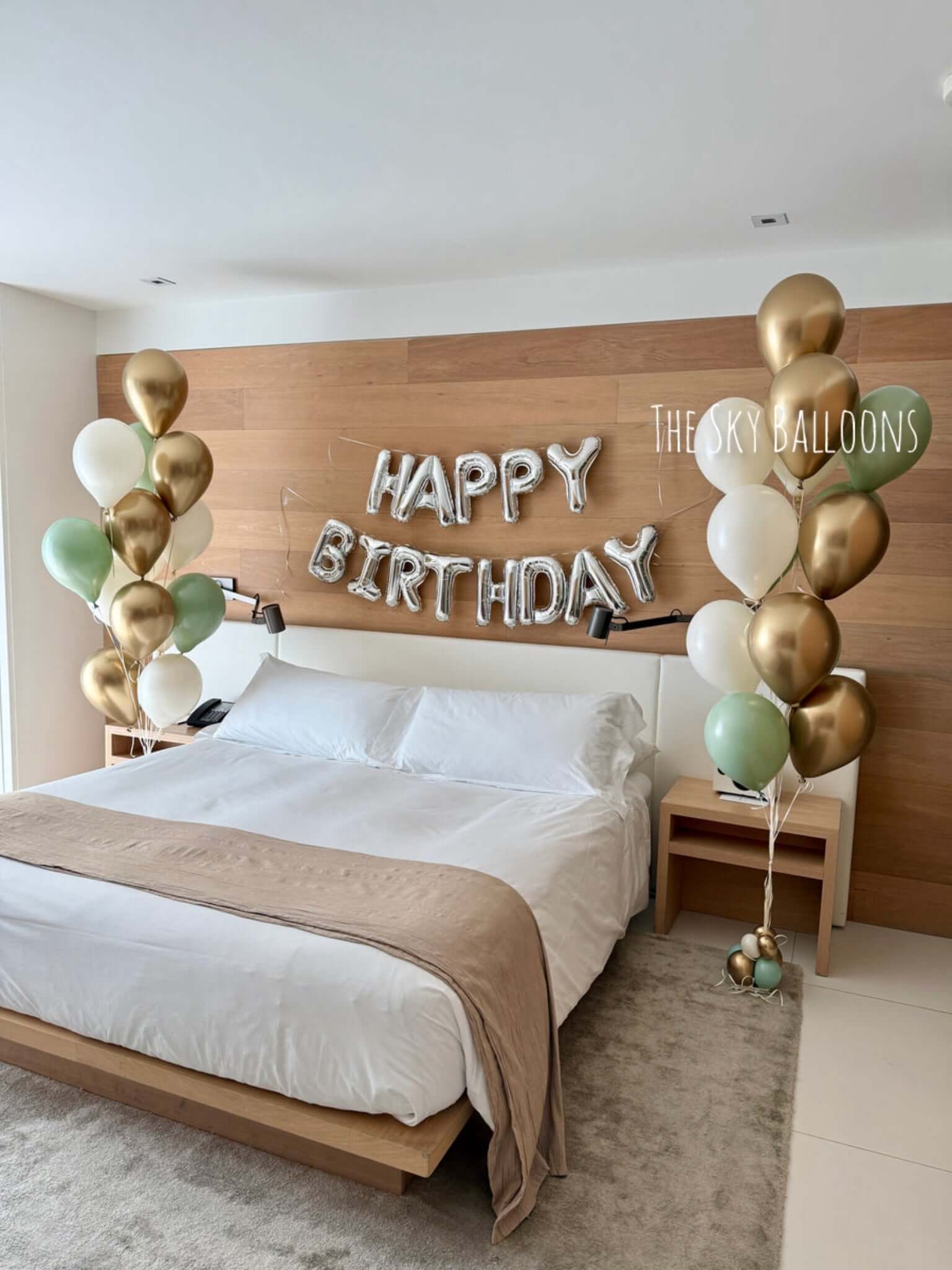 Bedroom with 'Happy Birthday' balloons and wooden headboard