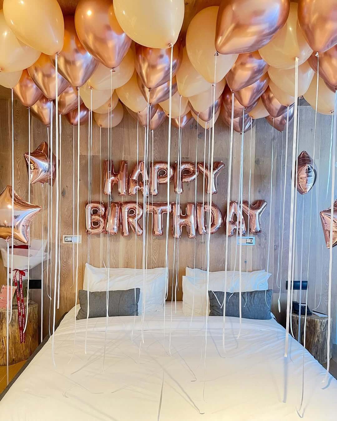 Bedroom with 'Happy Birthday' balloons above a bed