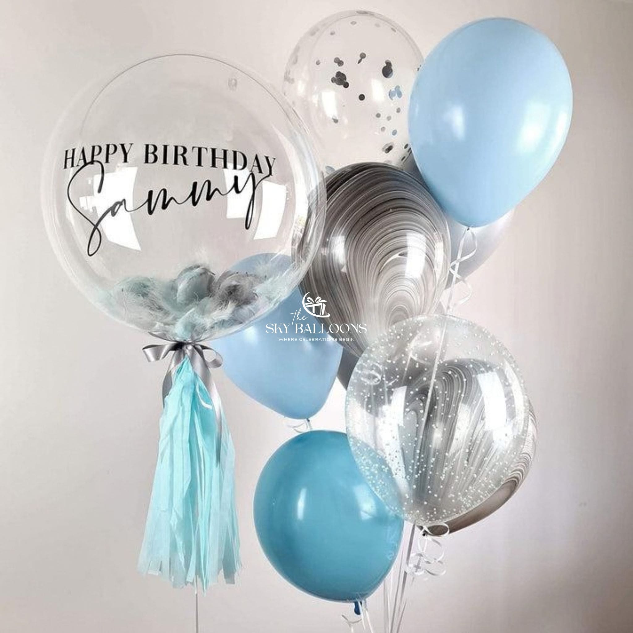 Balloon bouquet with 'Happy Birthday Sammy' on a clear balloon against a light background.