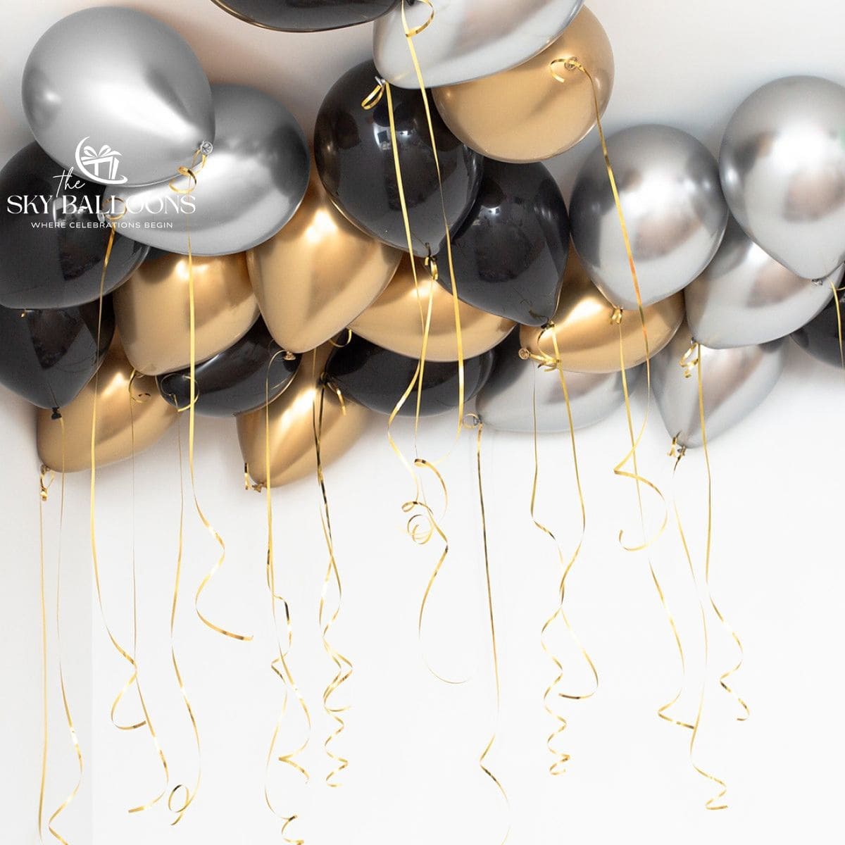 Black, chrome-gold and chrome-silver helium ceiling balloons with long gold curling ribbons.