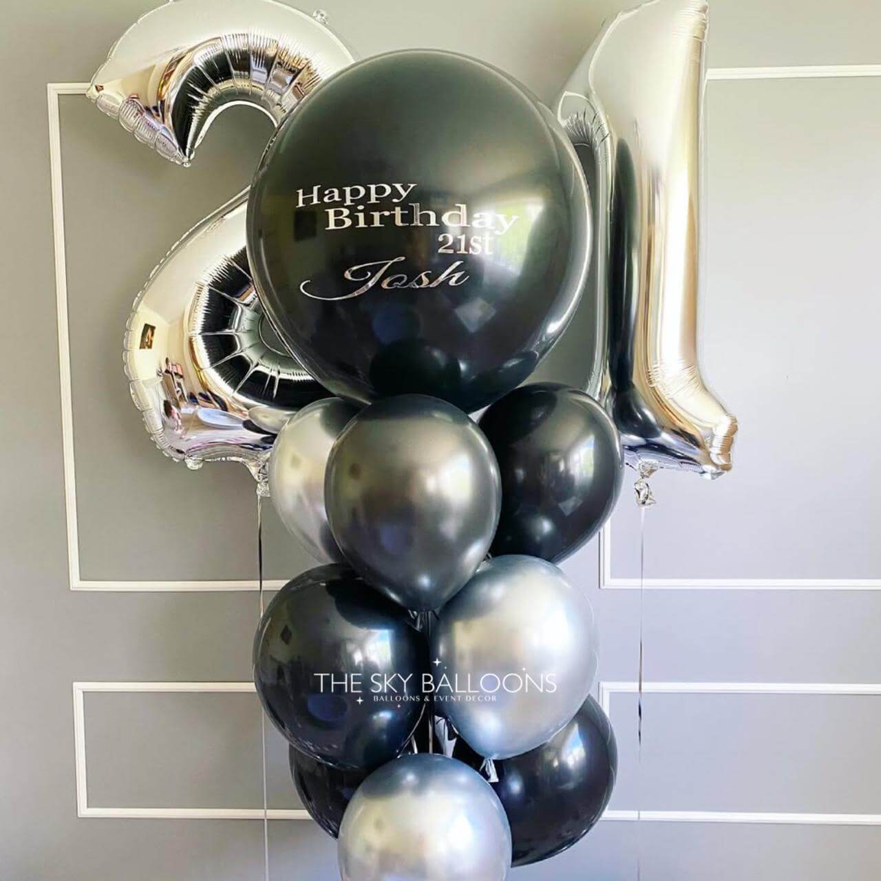 Black and silver balloons with 'Happy Birthday Josh' text on a light gray background