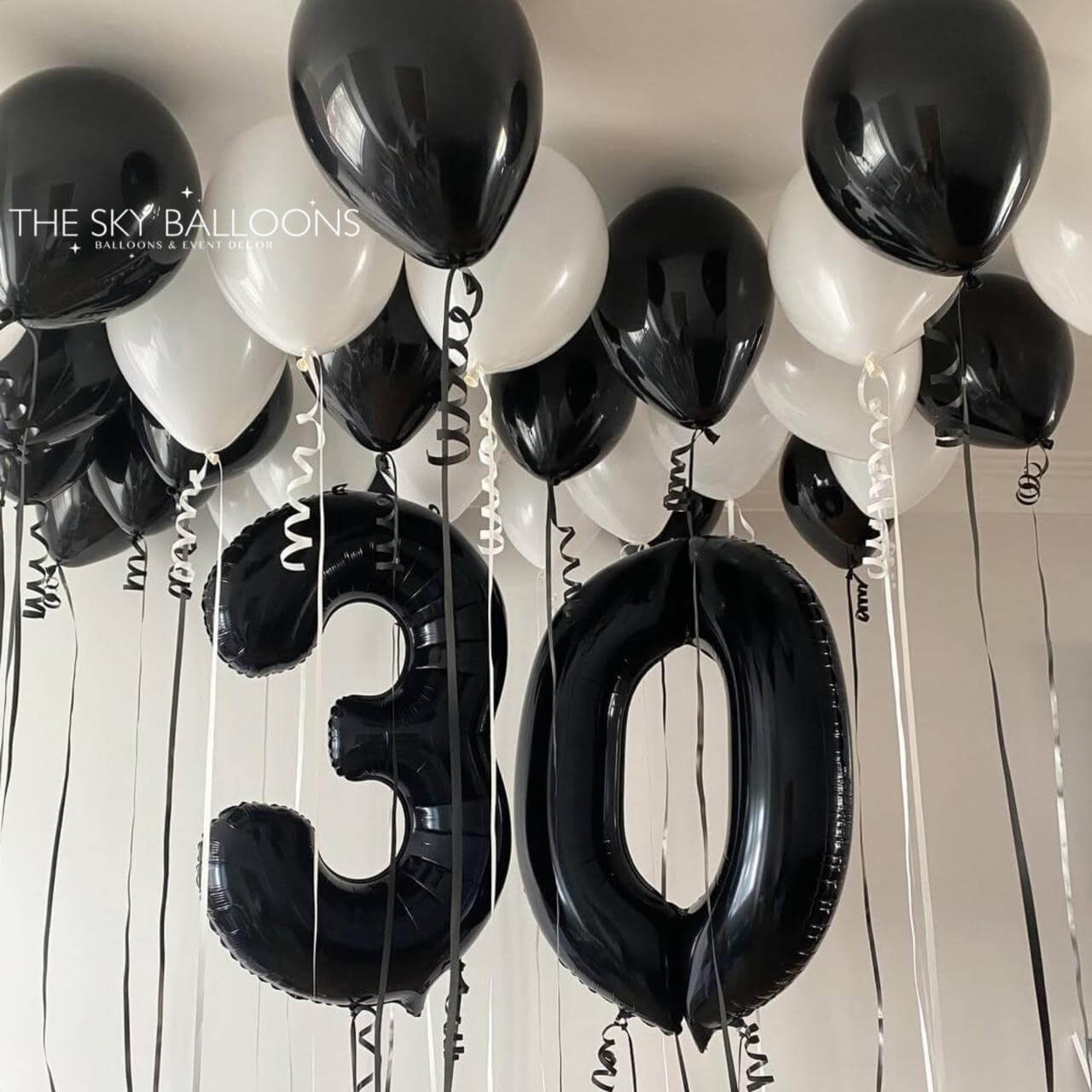 Black and white balloons with '30' on a light background