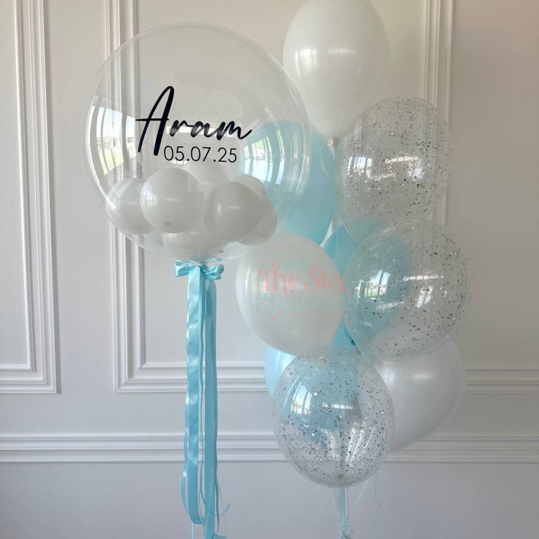 Decorative balloons with personalized text against a white wall