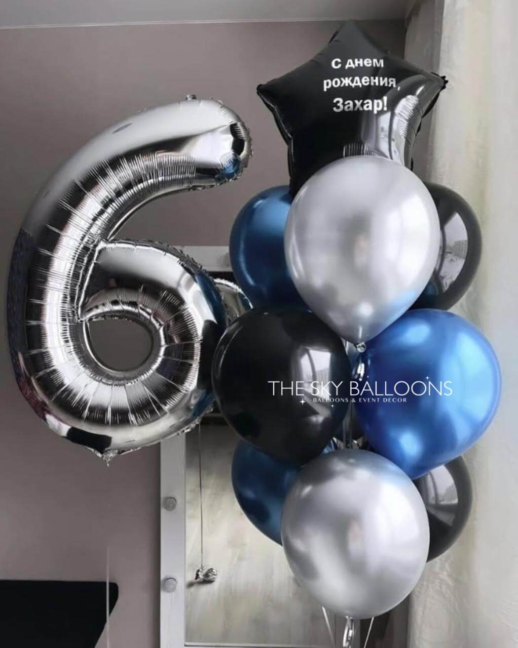 Bouquet of balloons including a large silver number '6' and various colored balloons with a visible brand name.