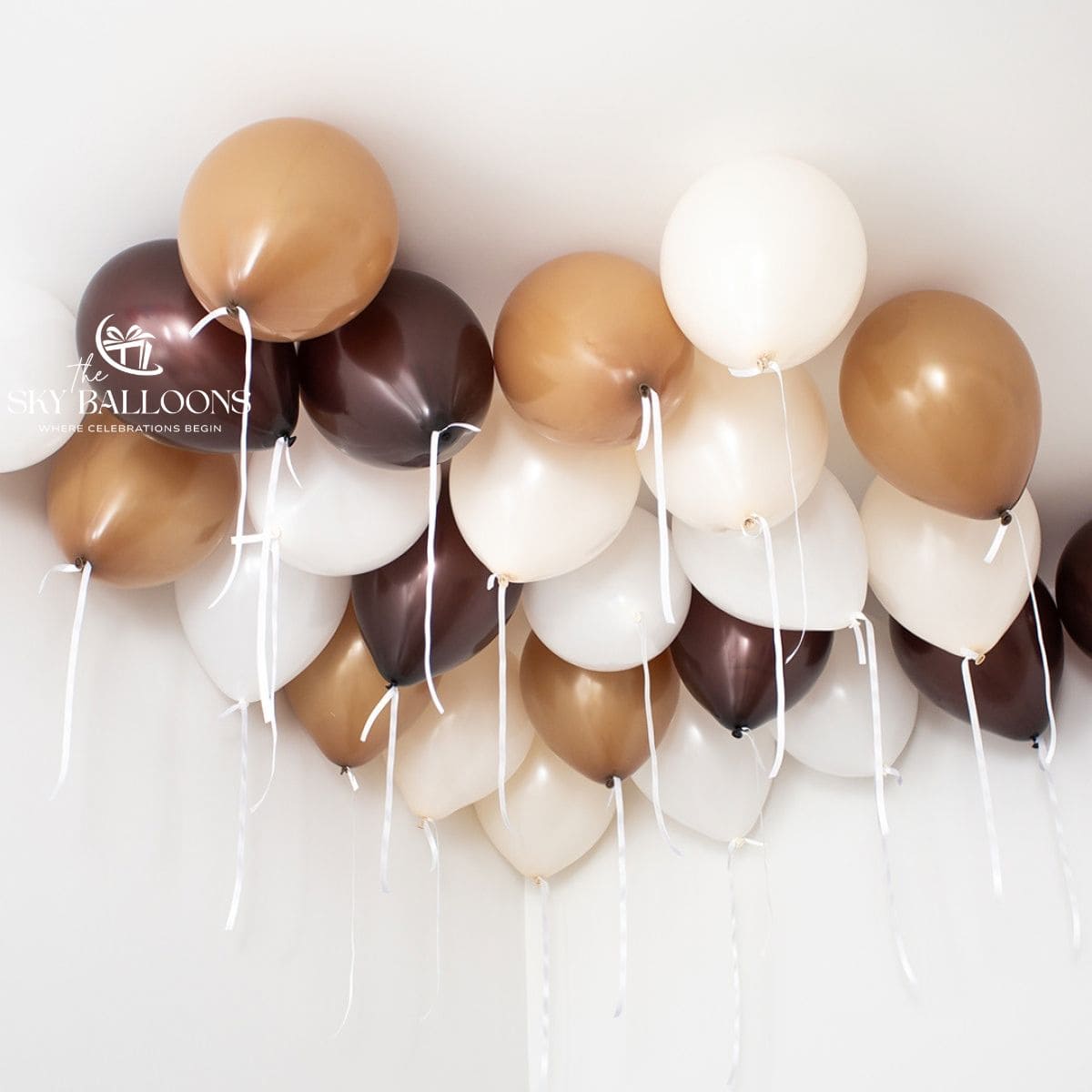 Chocolate-brown, caramel, cream and white helium ceiling balloons with hanging white ribbons.