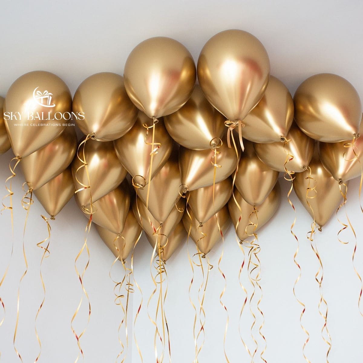 Chrome-gold helium ceiling balloons with hanging gold curling ribbons.