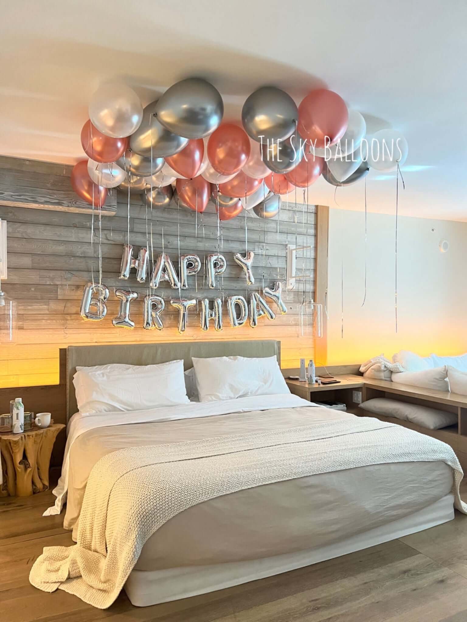 Decorated bedroom with balloons and 'Happy Birthday' sign
