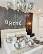 Decorated bedroom with balloons and 'BRIDE' sign, likely for a wedding preparation.