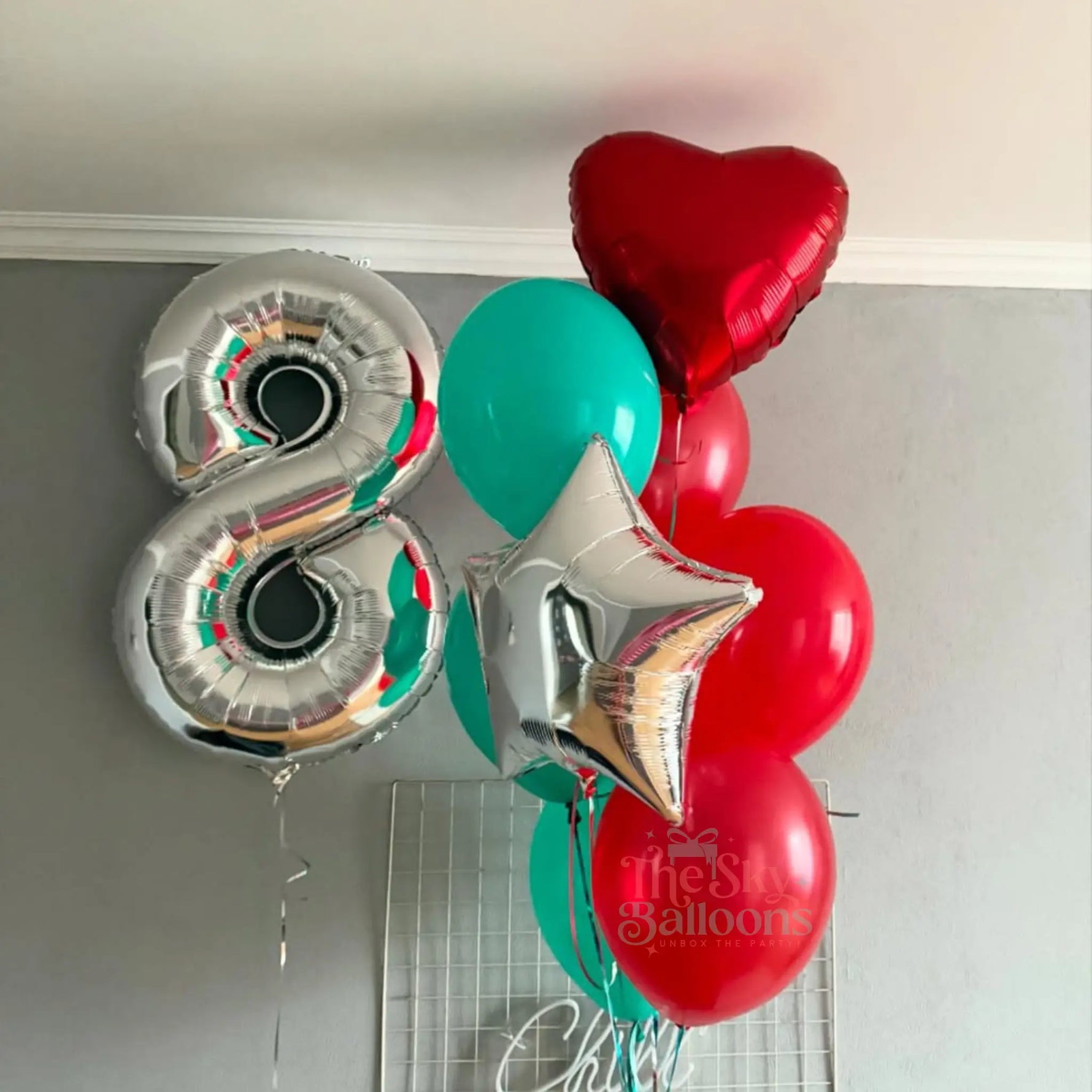 Decorative balloons including a silver number 8, red heart, and green star on a white background.