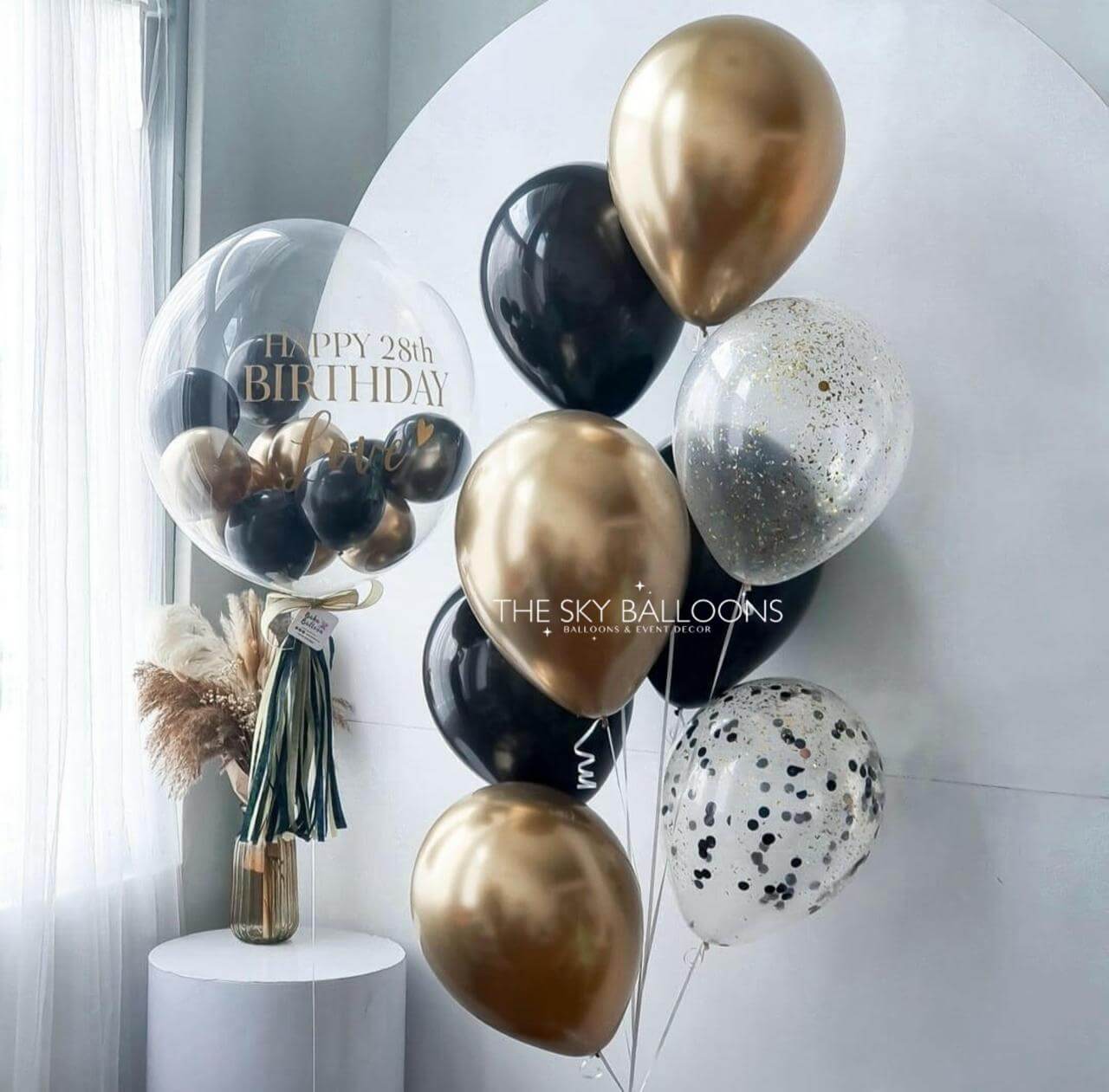 Decorative balloons with a bouquet on a white background, featuring 'The Sky Balloons' brand.