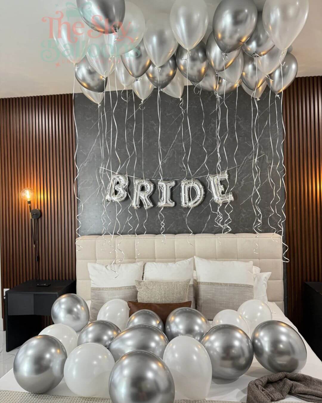 Decorative setup with balloons and 'BRIDE' letter balloons in a bedroom.