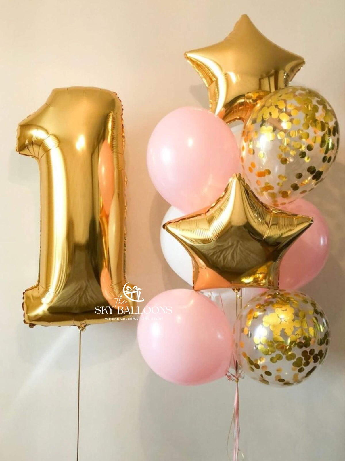 Gold number 1 foil balloon with two gold stars, pink and white latex balloons, and clear gold-confetti balloons.