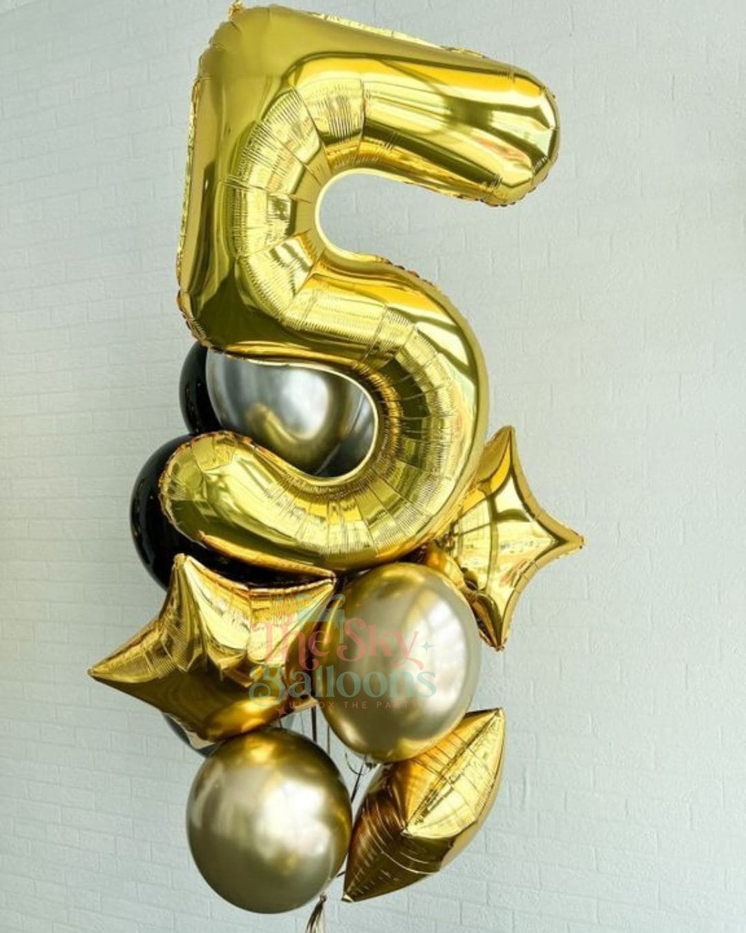 Gold number 5 balloon with decorative elements on a light gray background