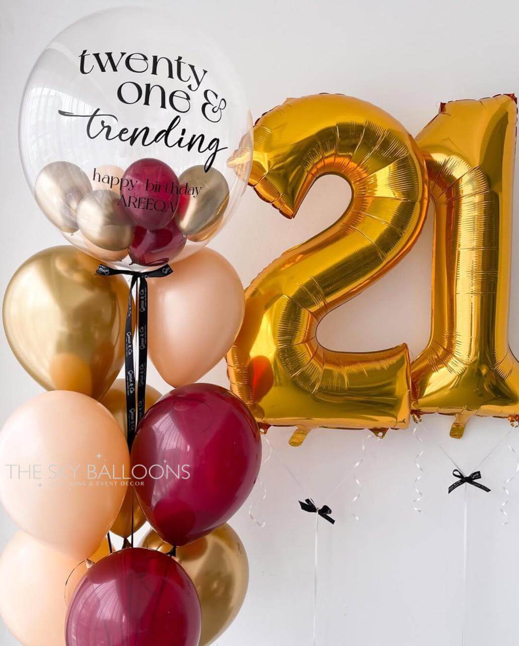 Gold number '21' balloon and other balloons on a white background