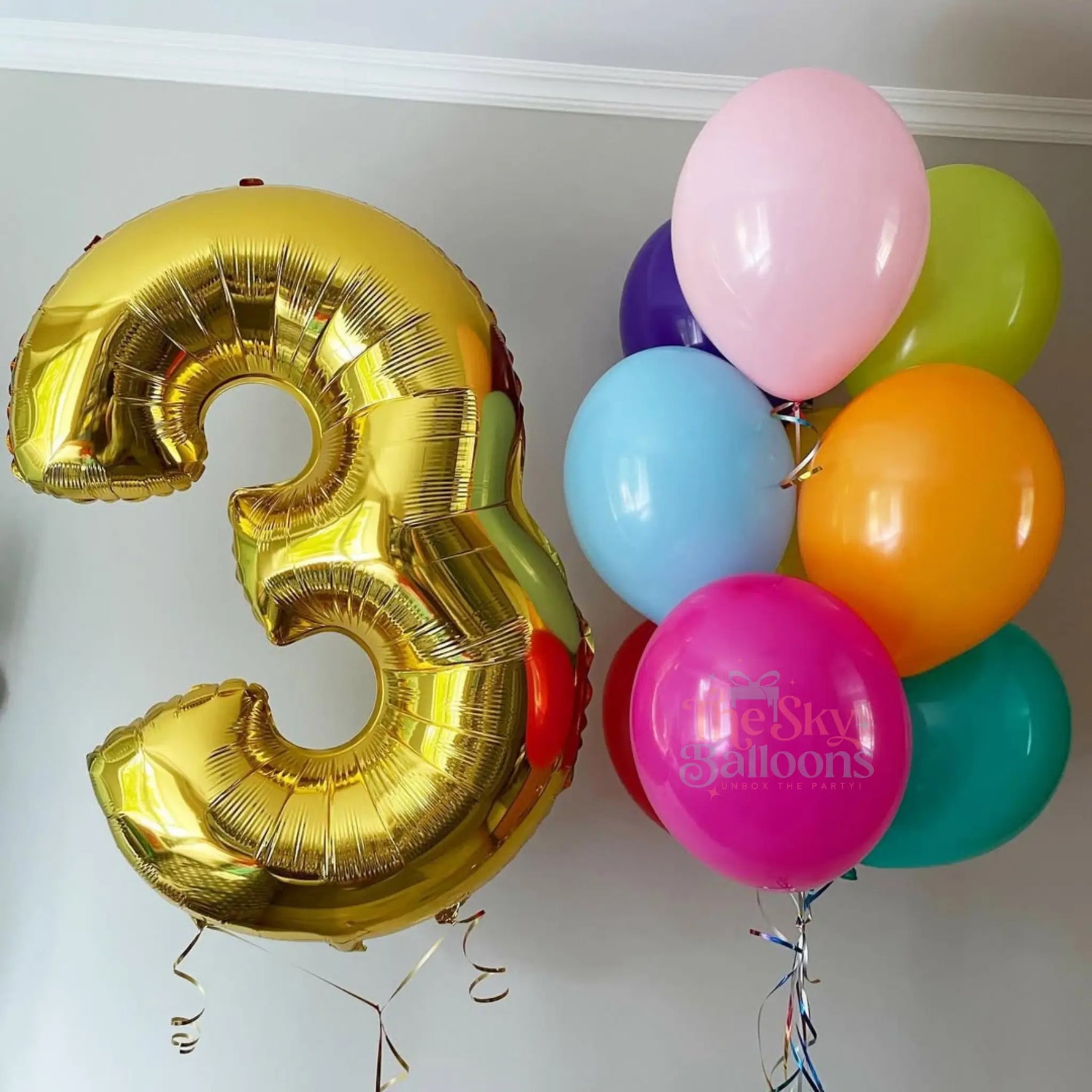 Gold number 3 balloon and colorful bunch of balloons on a white background