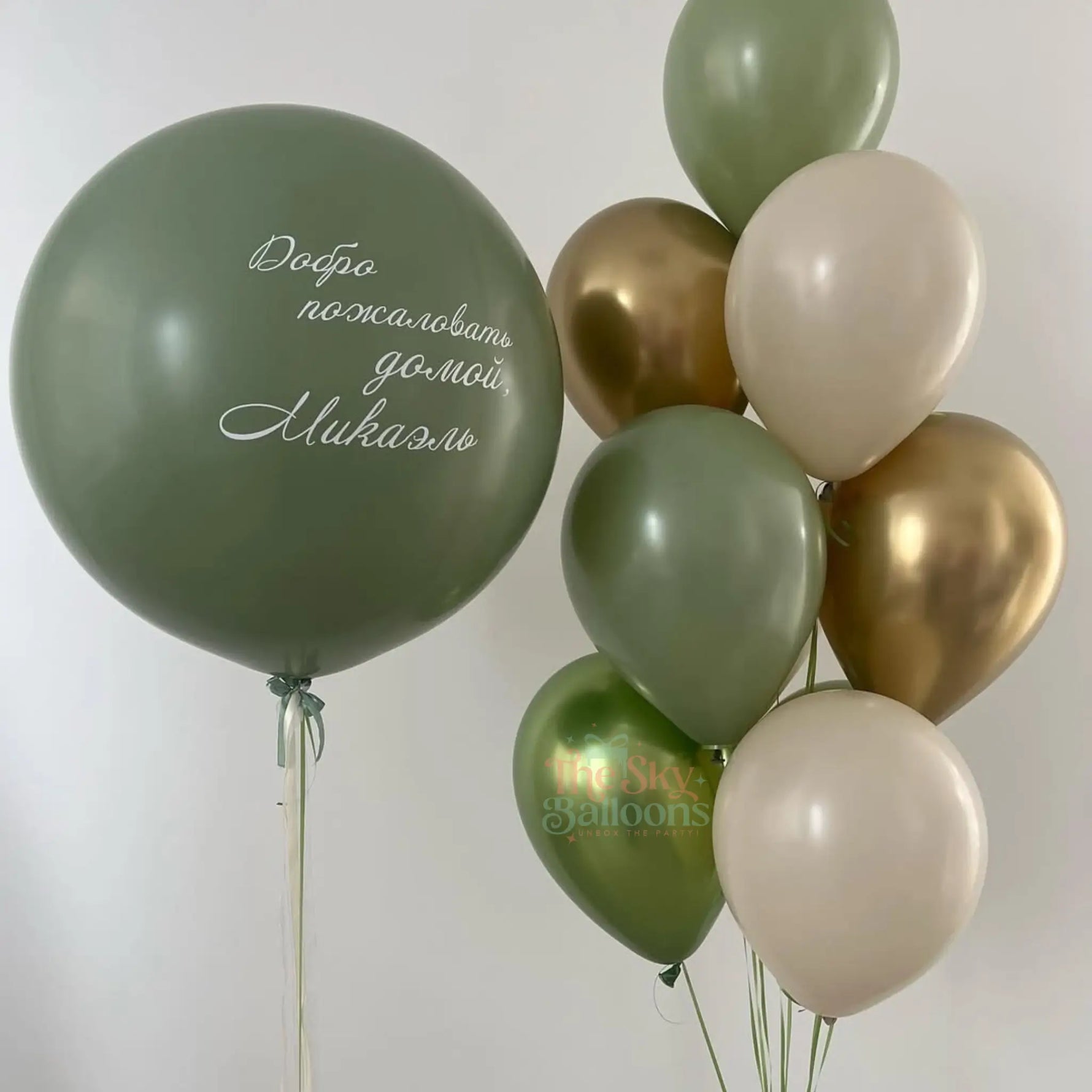 Green, gold, and beige balloons with text on a white background