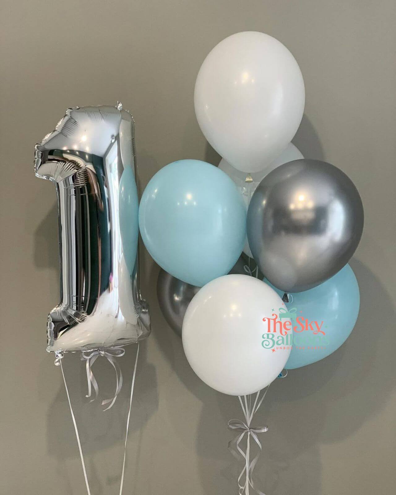 Silver number 1 balloon and cluster of balloons on a neutral background