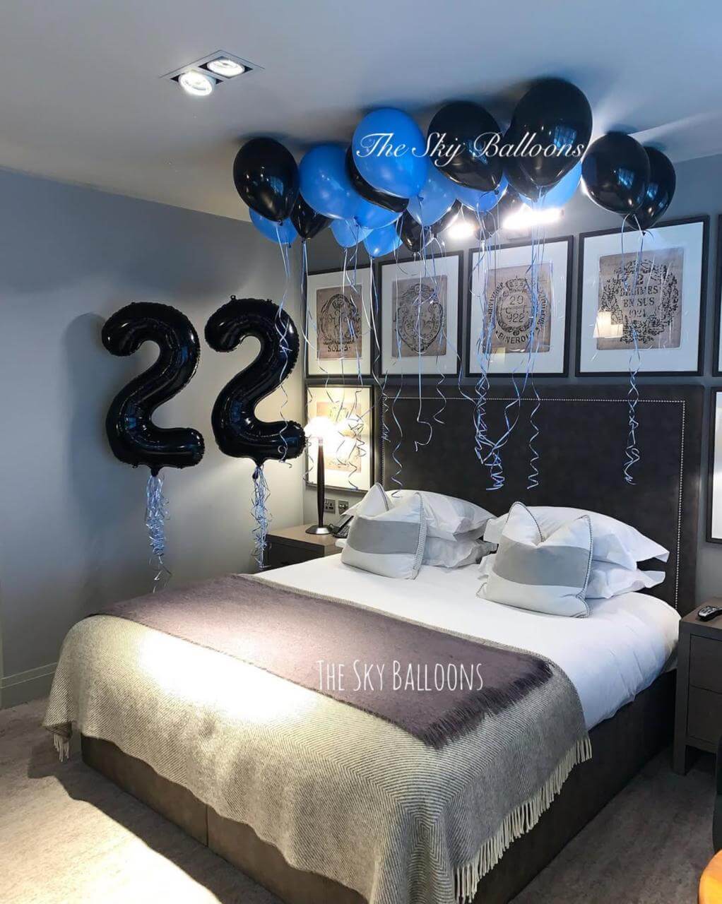 Decorated bedroom with balloons and '22' balloons over a bed.