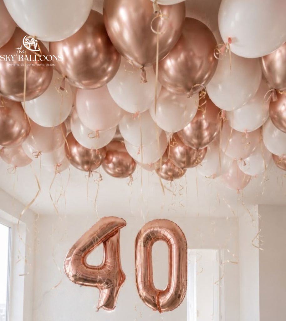40th birthday room decoration with rose gold number 40 foil balloons beneath white, blush pink and metallic rose gold ceiling balloons with curling ribbons.