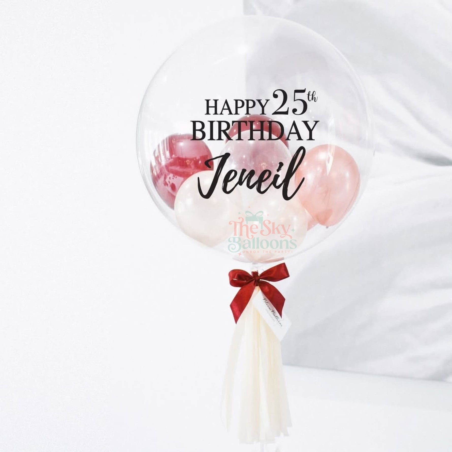 Personalized birthday balloon with pink balloons and a red bow on a white background