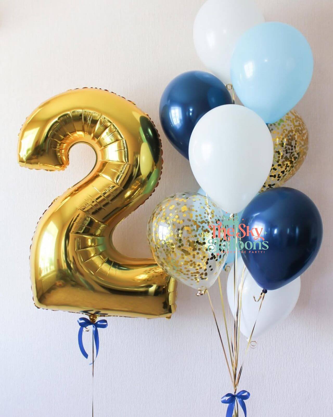 Gold number 2 balloon with a cluster of other balloons on a white background