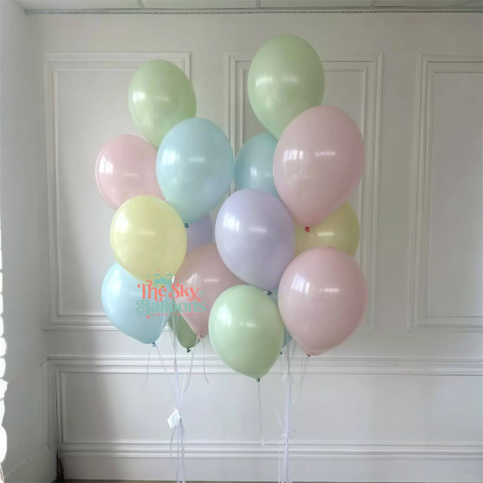 Pastel-colored balloons against a white paneled wall