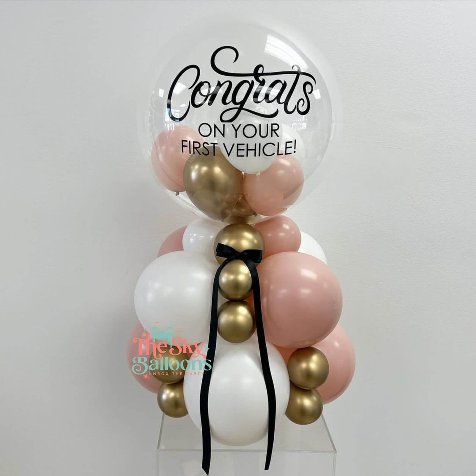 Decorative balloon arrangement with 'Congrats on your first vehicle!' text on a white background.