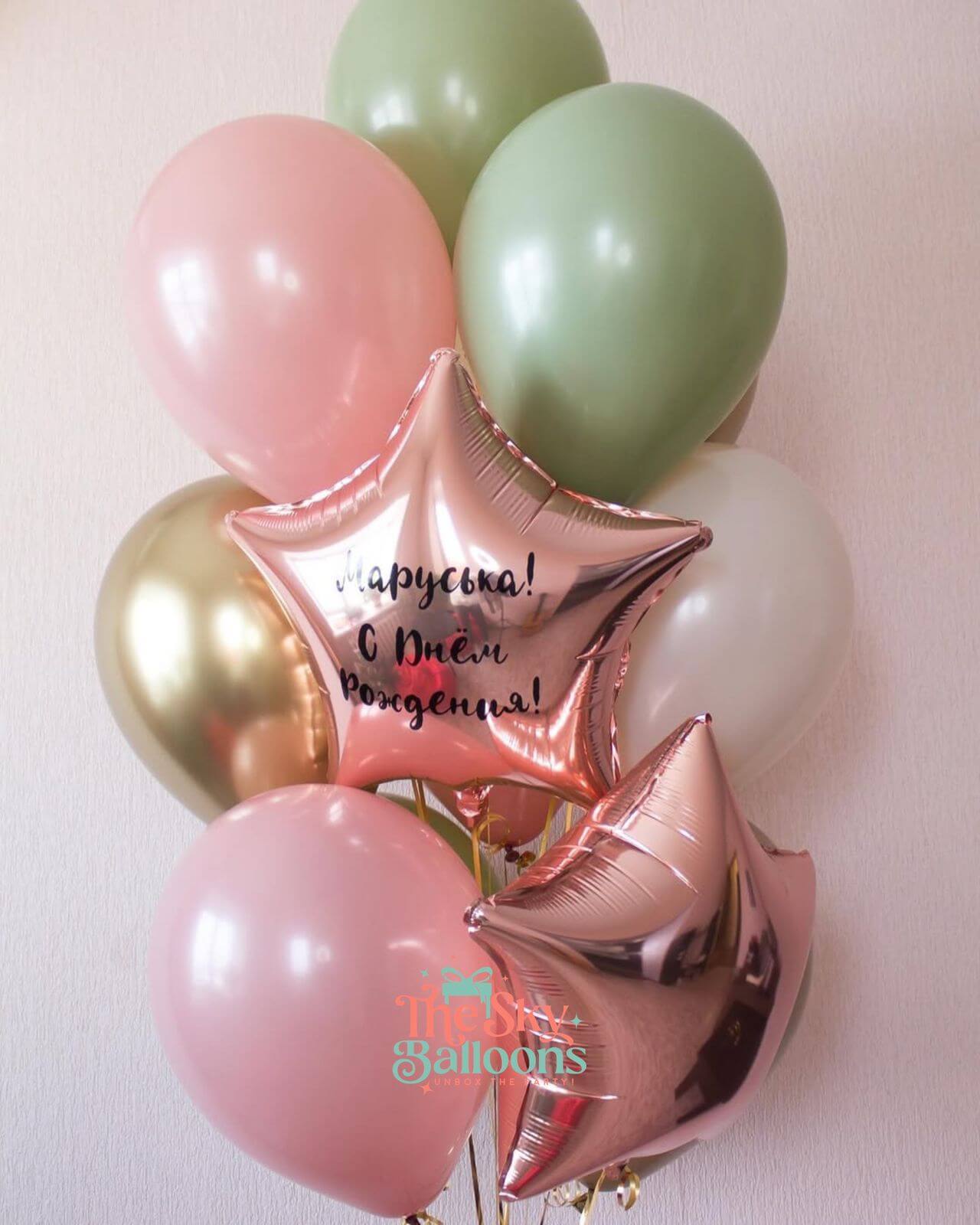 Balloon bouquet with pink, green, and gold balloons featuring a star-shaped foil balloon with text on a light pink background.