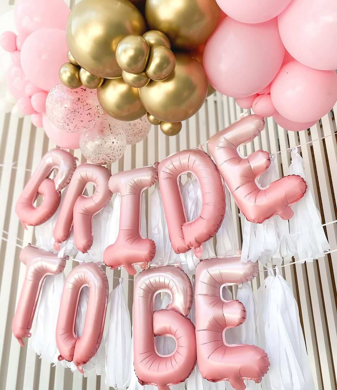  with gold and pink balloons against a neutral background