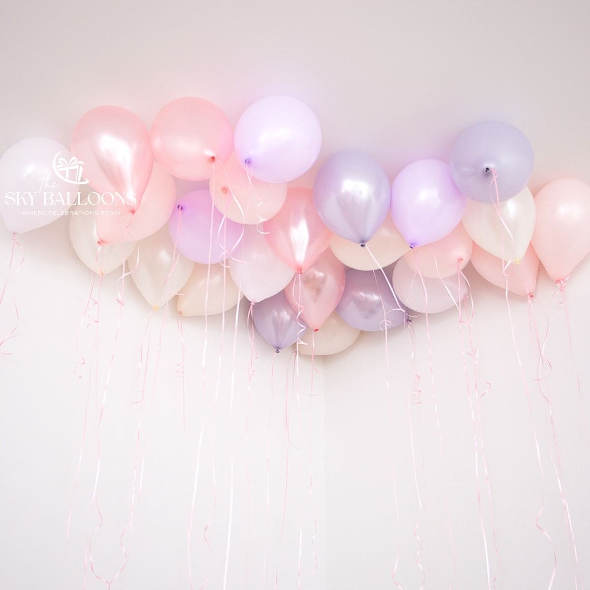 Pastel pink, lilac, white and ivory helium ceiling balloons with hanging curling ribbons.