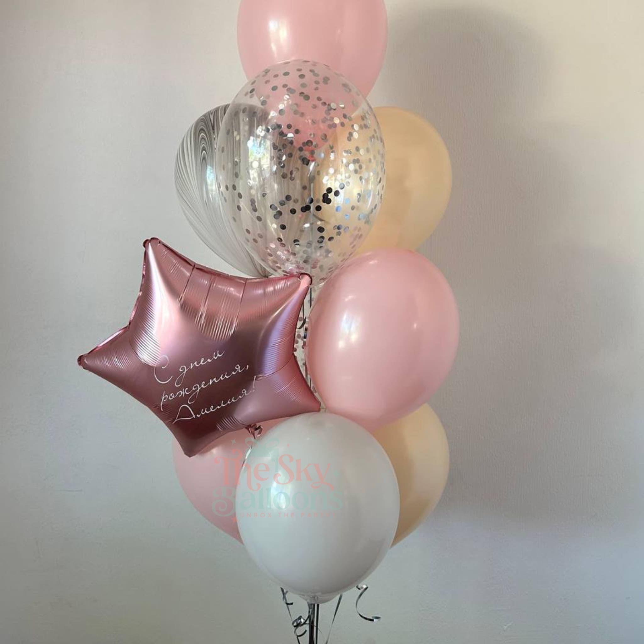 Bouquet of balloons including pink, silver, and gold balloons with a star-shaped balloon featuring text.