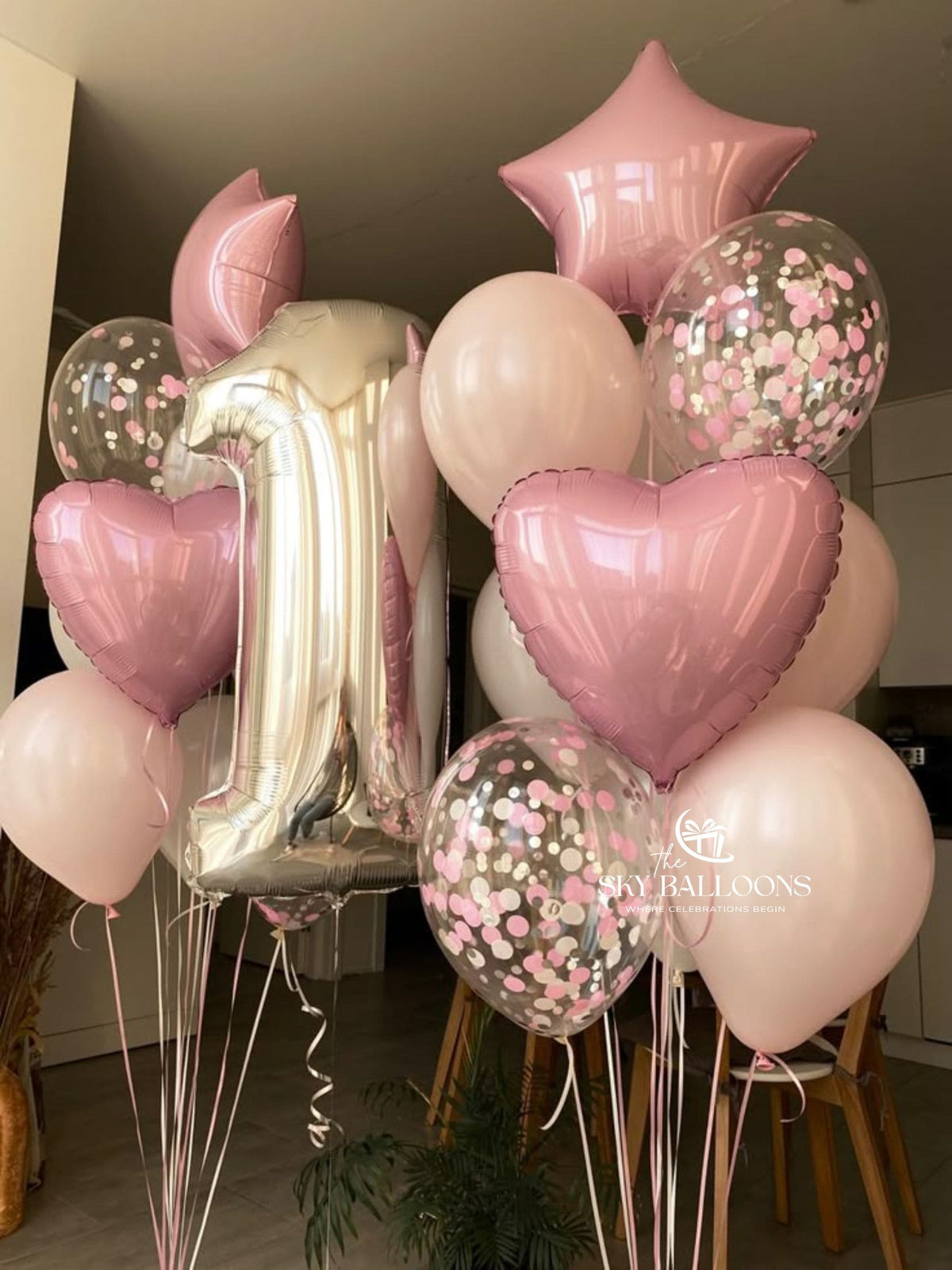 Silver number 1 foil balloon with two pastel pink balloon bouquets featuring pink hearts, stars and clear pink-confetti balloons.