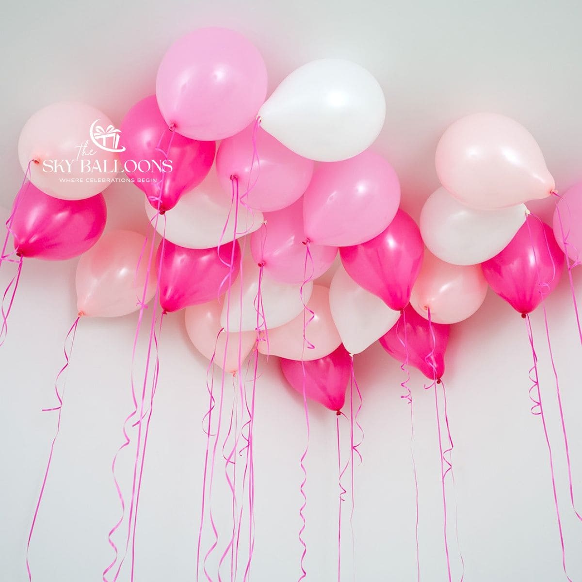 Pink, blush-pink, white and metallic-fuchsia helium ceiling balloons with hanging pink curling ribbons.