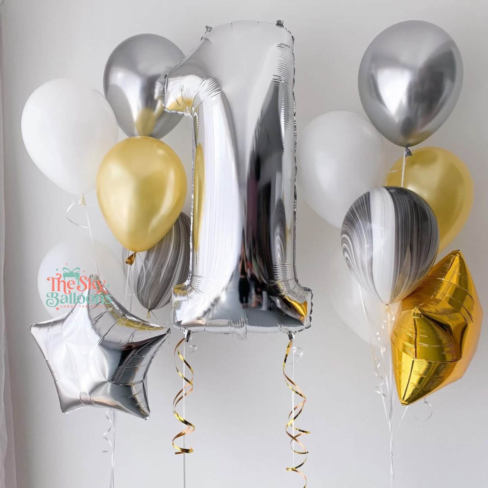 Decorative balloons with silver, gold, and white colors on a plain background