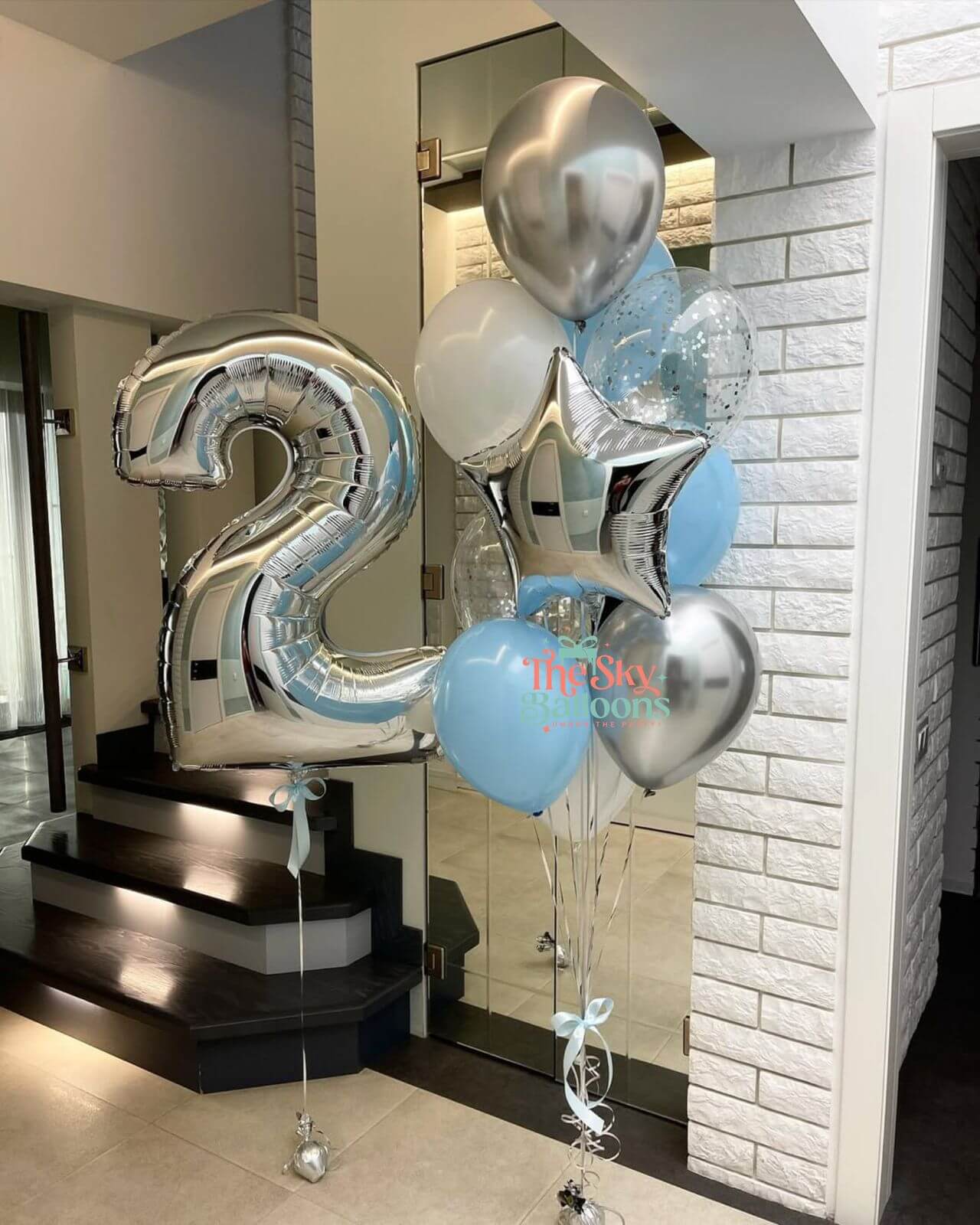 Silver number 2 balloon and other balloons in a modern interior setting.