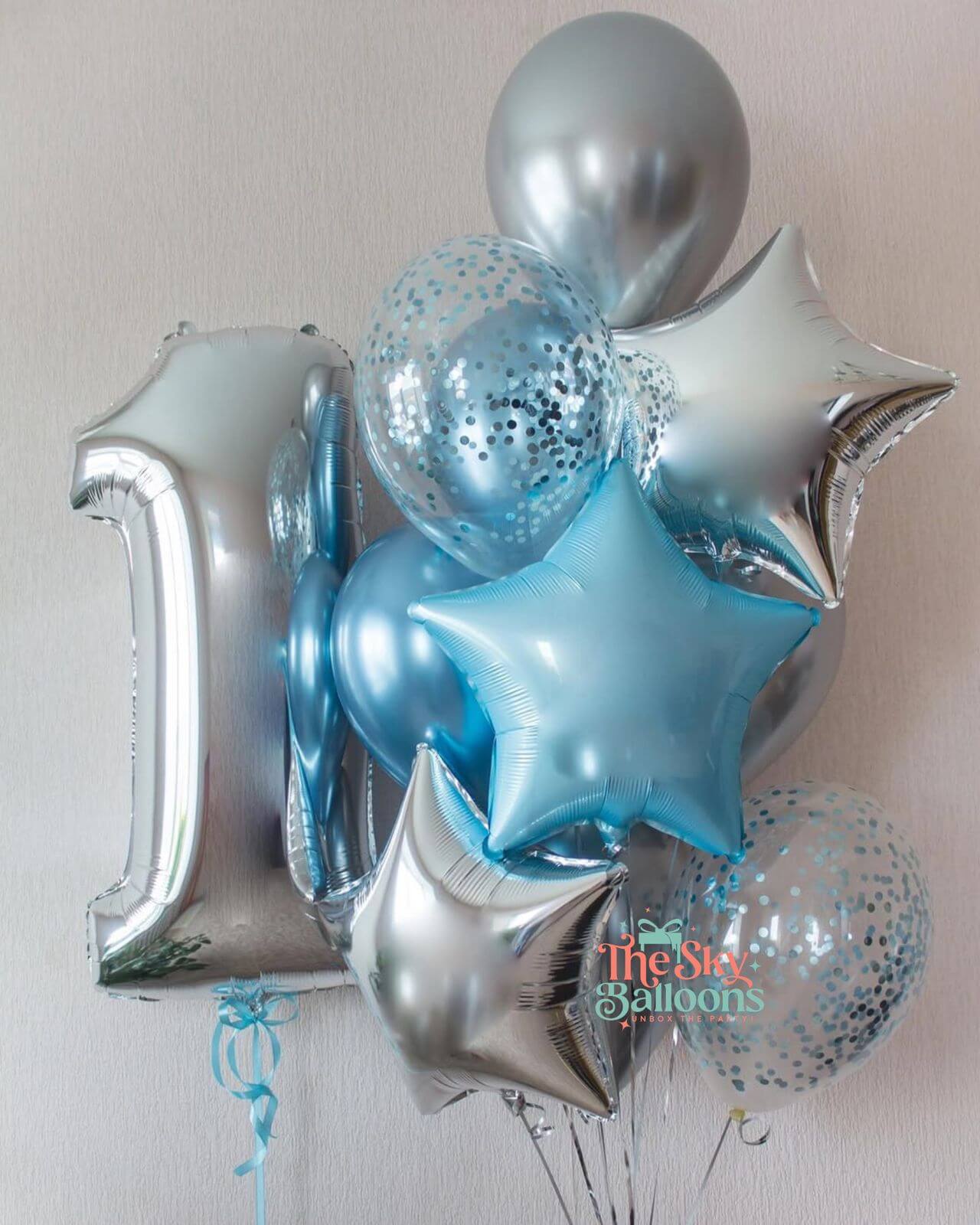 Balloon bouquet with silver and blue balloons on a light background
