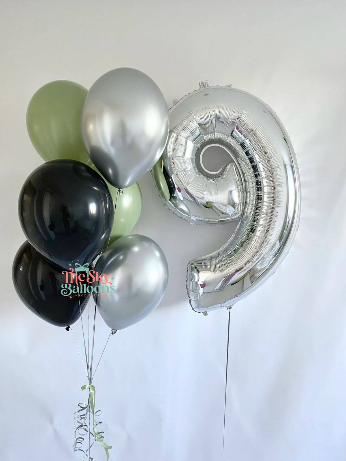 Set of balloons including a silver number 9 balloon on a white background