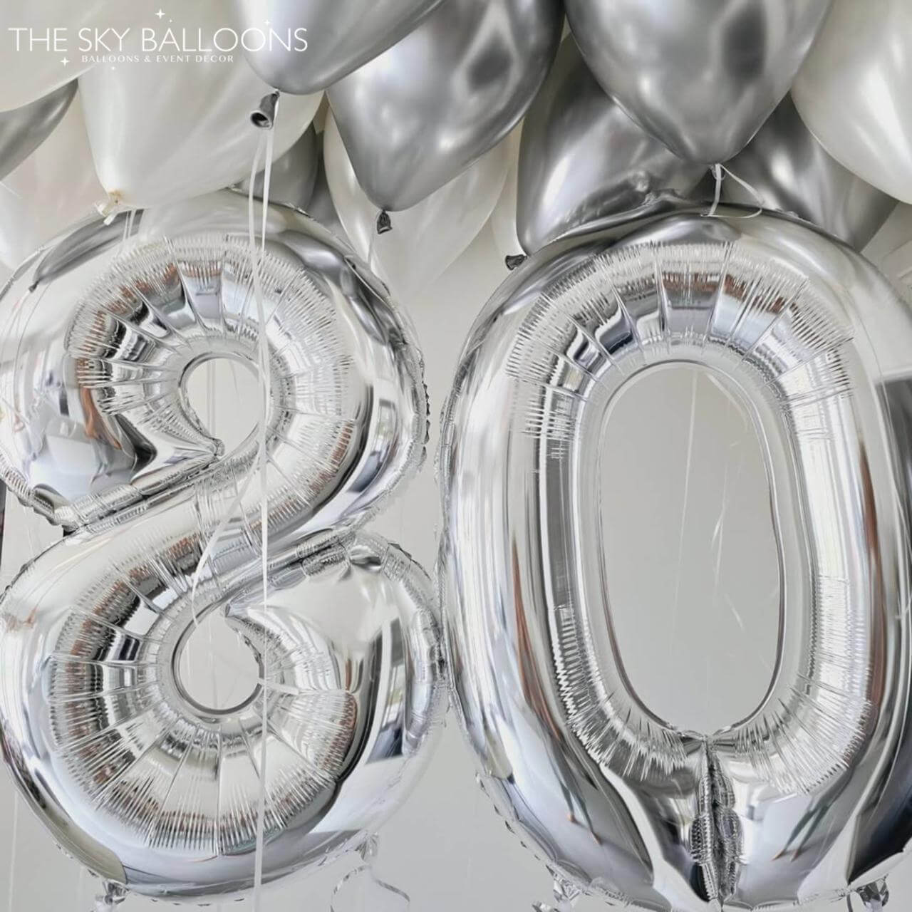 Silver number balloons spelling '38' against a white background