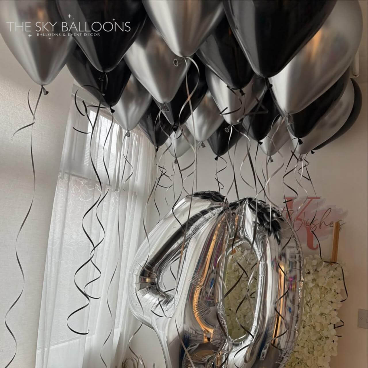 Silver balloons with a number '40' against a neutral background