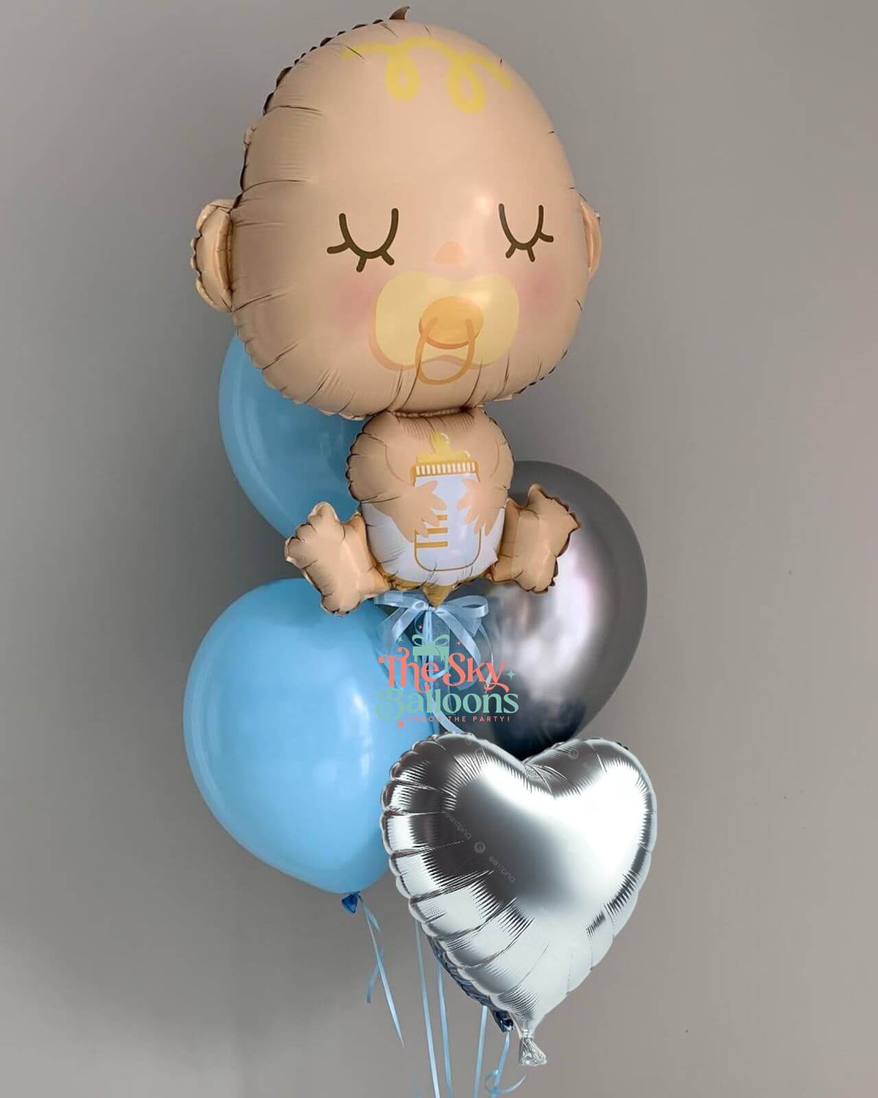 Baby-shaped balloon with blue and silver balloons on a gray background