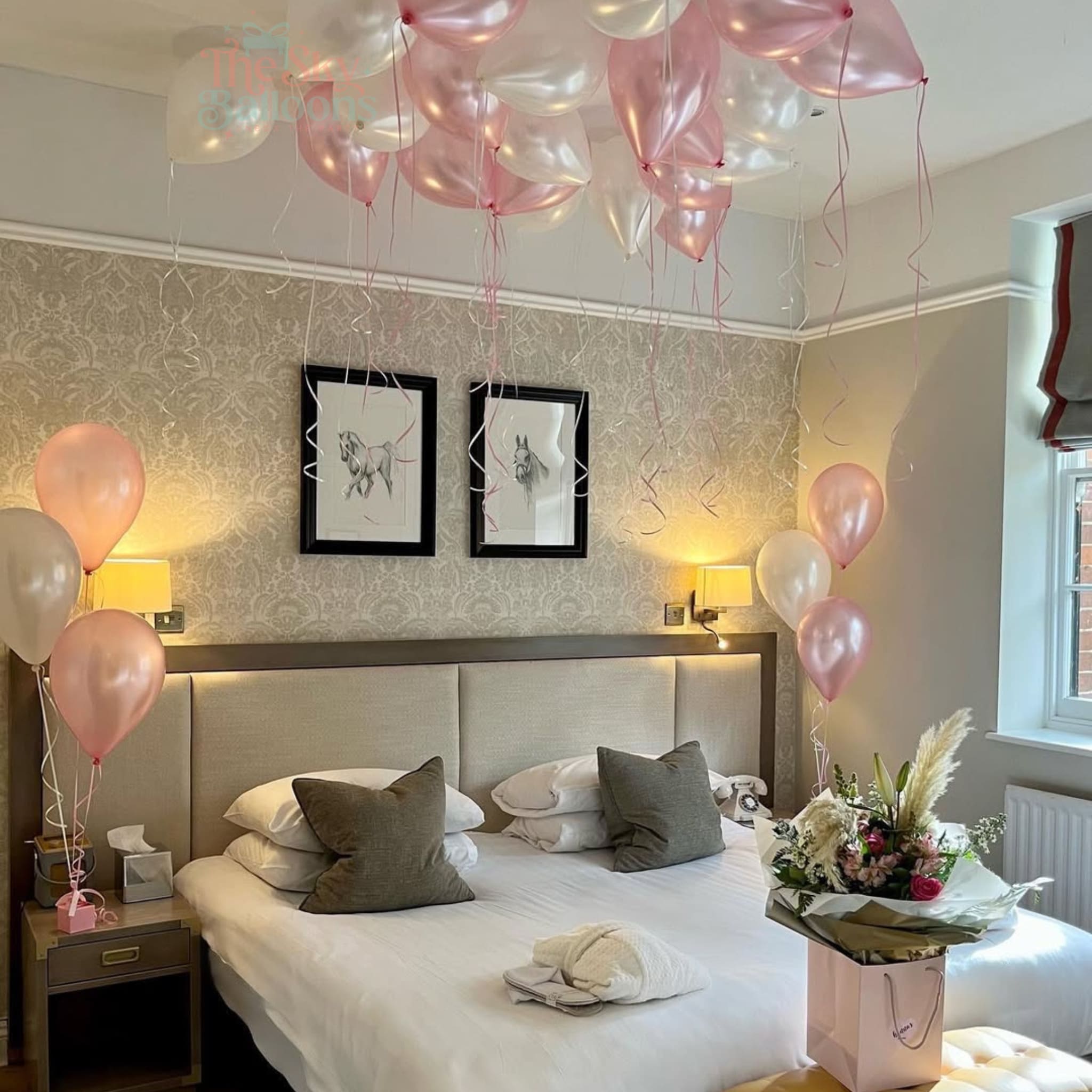 Decorated bedroom with balloons and a bouquet of flowers.