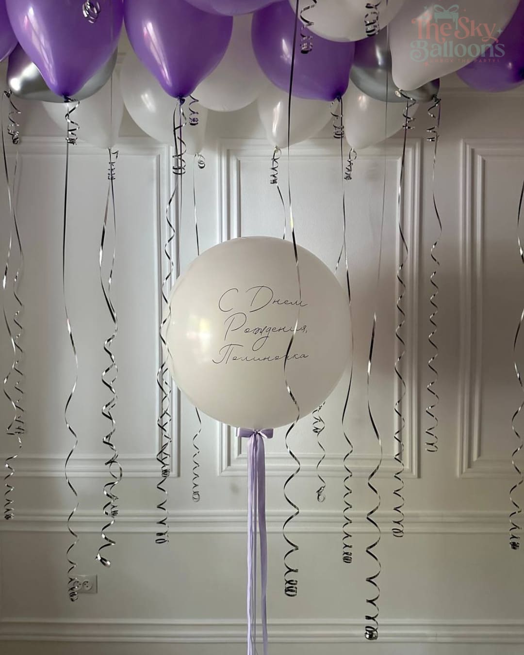 Decorative balloons with text on a white paneled wall