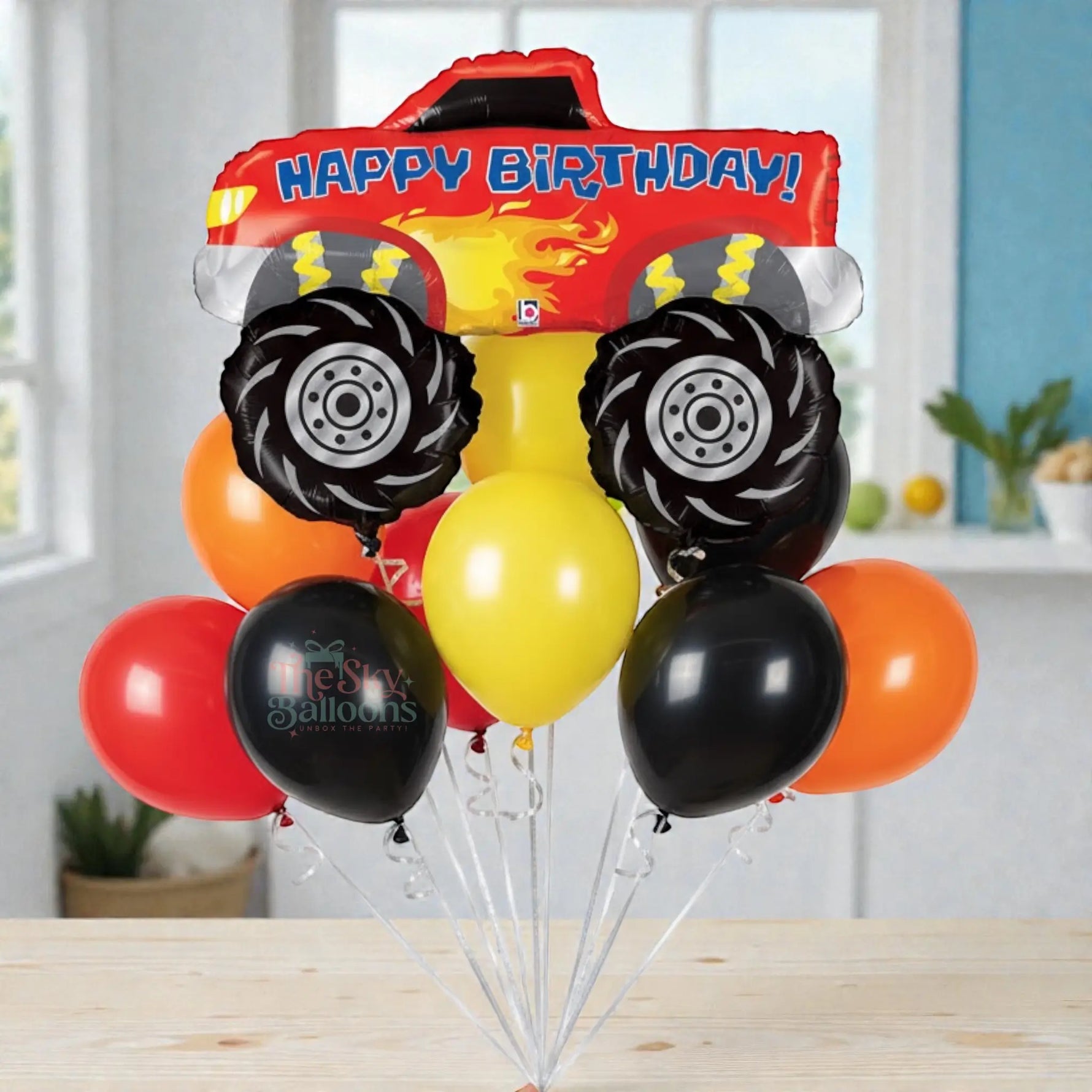 Balloon bouquet shaped like a fire truck with 'Happy Birthday!' text on a white background