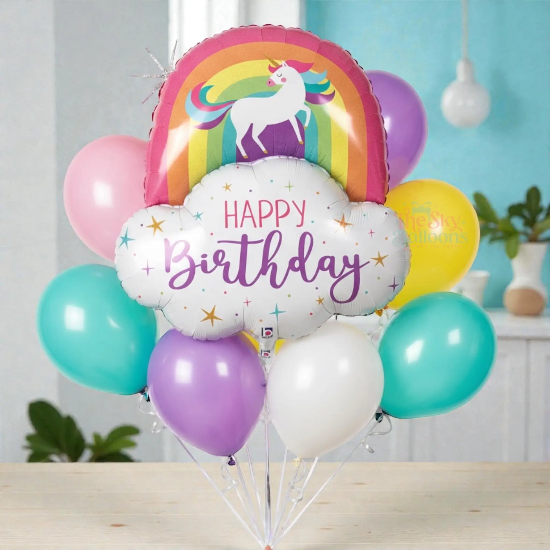Colorful birthday balloon bouquet with a unicorn and rainbow design on a white background