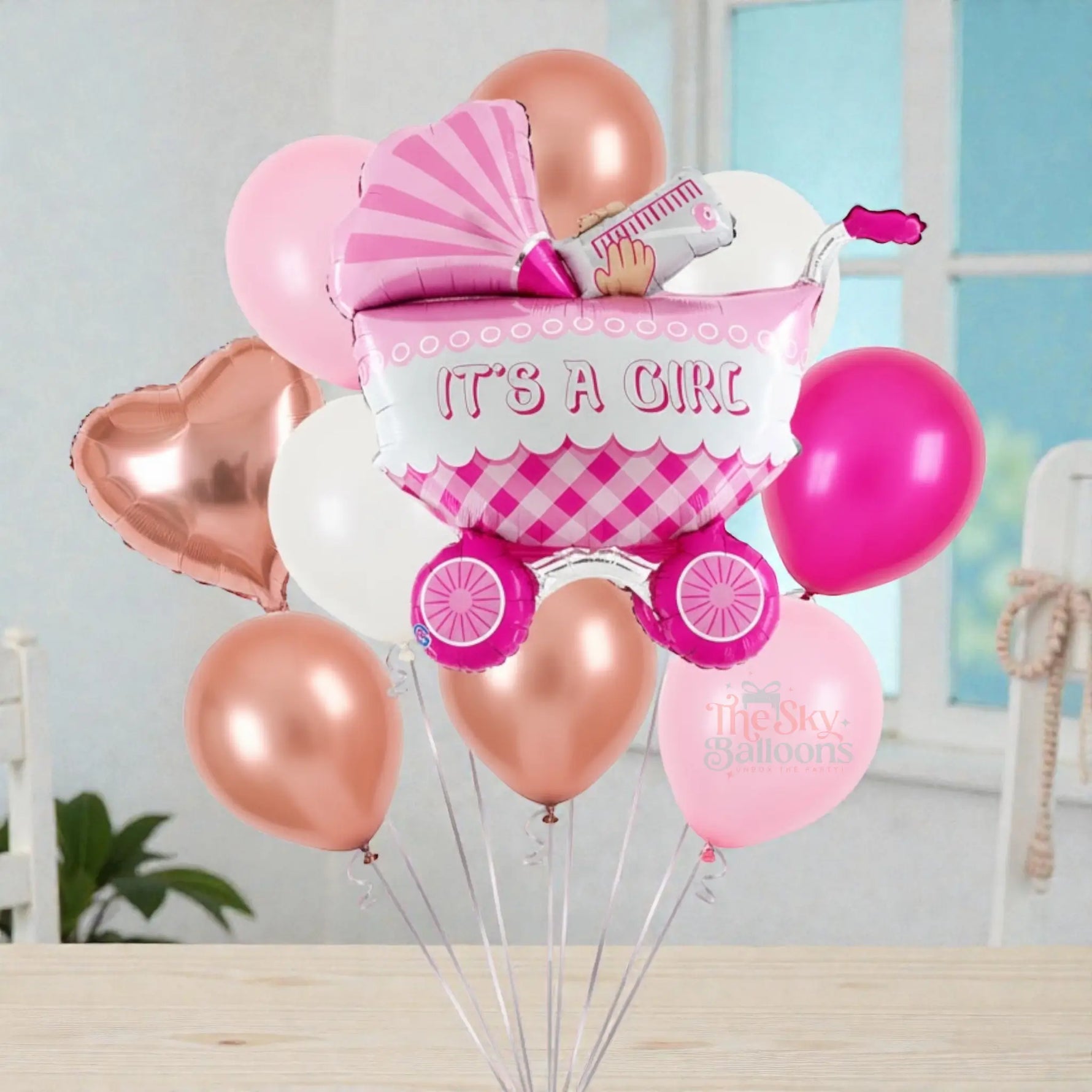 Balloon bouquet with 'It's a Girl' message and baby stroller design on a white background