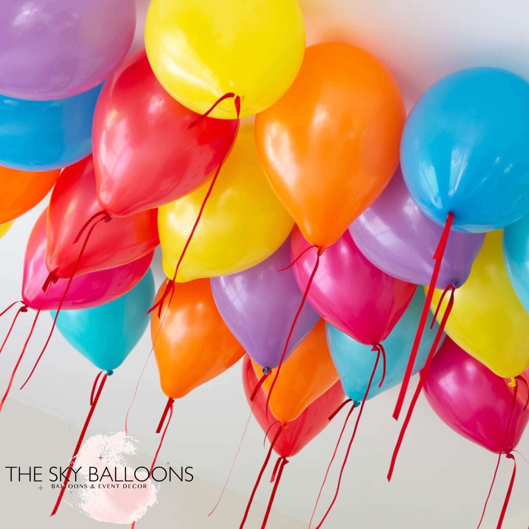 A cluster of colorful helium-filled ceiling balloons in red, blue, yellow, and purple, delivered inflated and ready to float.