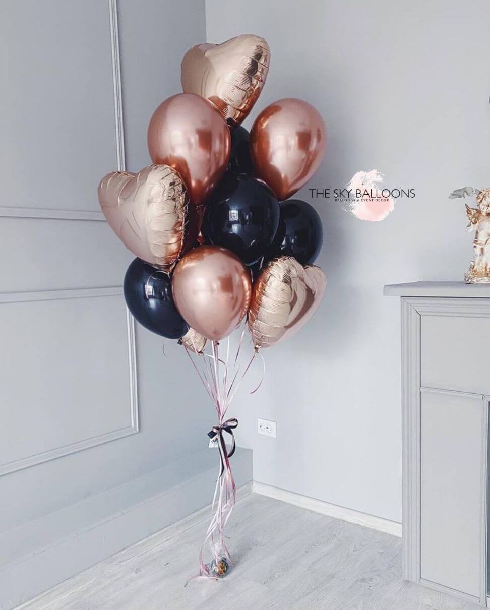 A bouquet of rose gold and black balloons placed near a door, with 'The Sky Balloons' written on the image.