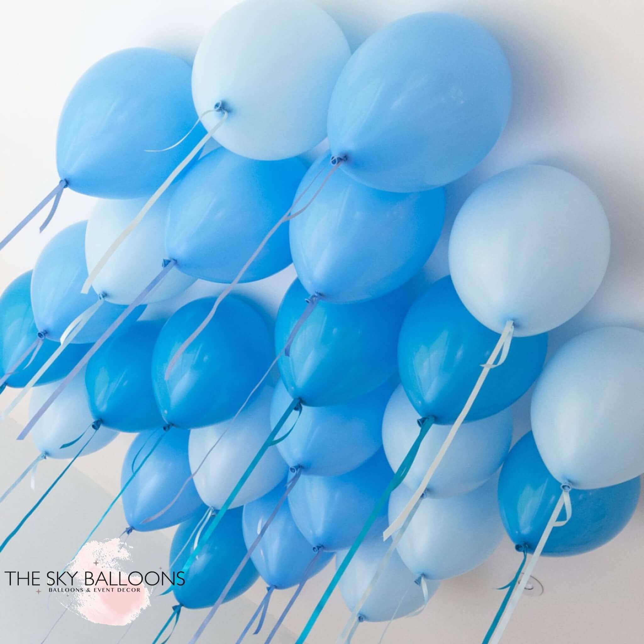A cluster of sky blue helium ceiling balloons arranged to float in a group against a white background.