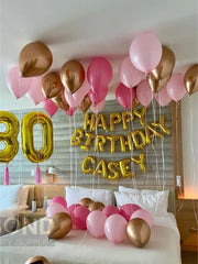 Festive bed with colorful balloons and a birthday sign, perfect for a birthday surprise.